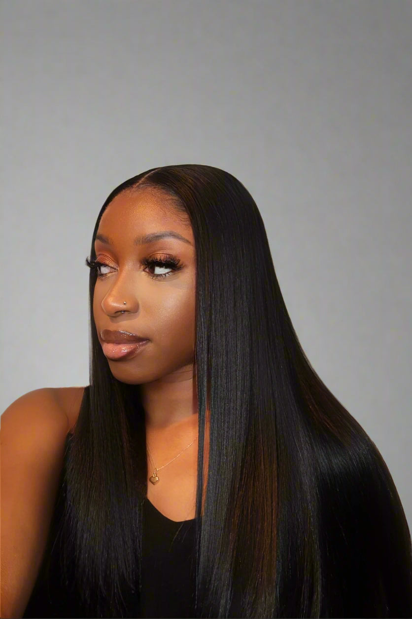 Woman with long straight black hair against a plain background